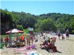 View larger image of Kids playing in the water and people lying on sand at AUSTIN LAKE RV PARK  CABINS image #3