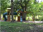 View larger image of The playground area under trees at COLORADO LANDING RV PARK image #10