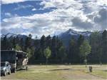 Snowy mountains in horizon with RV and dinghy in foreground at IRVIN'S PARK & CAMPGROUND - thumbnail