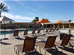 View larger image of Swimming pool with outdoor seating and orange umbrellas at FAR HORIZONS RV RESORT image #1