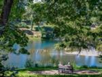 Couple sitting on a bench by the river at RISING RIVER RV RESORT & RIVER HOUSE - thumbnail