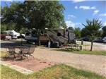 View larger image of Travel trailer parked near picnic table near tree at WOODLAND LAKES RV PARK image #3