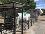 View larger image of Large propane tank surrounded by chain linked fence at WOODLAND LAKES RV PARK image #8