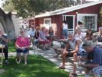 People in a community area sitting under shade trees at PASO ROBLES RV RANCH - thumbnail