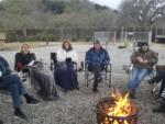 People sitting in a circle around a camp fire ring at PASO ROBLES RV RANCH - thumbnail