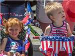 Two kids watching a 4th of July parade at SUGAR RIDGE RV VILLAGE & CAMPGROUND - thumbnail