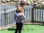 A couple of women playing miniature golf at SUGAR RIDGE RV VILLAGE & CAMPGROUND - thumbnail