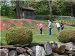 A family walking with golf clubs at SUGAR RIDGE RV VILLAGE & CAMPGROUND - thumbnail