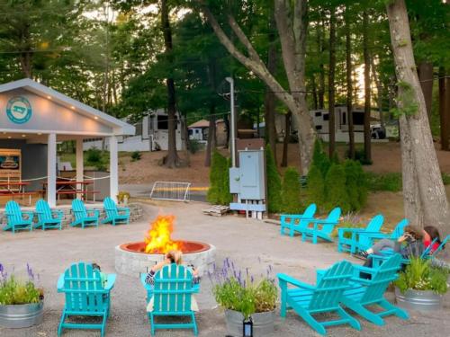 Fire pit surrounded by blue Adirondack chairs