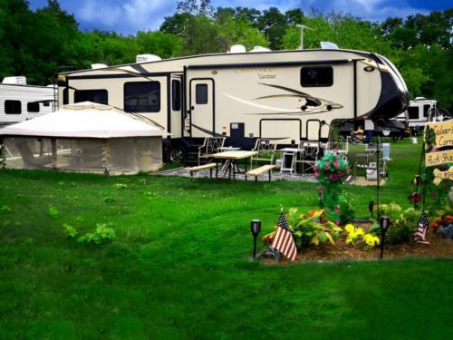 RV parked in a site near grassy lawn