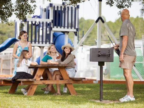 A family sits at a picnic table at Bayberry RV Park