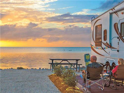 Couple sitting next to RV viewing the sunset at ENCORE FIESTA KEY