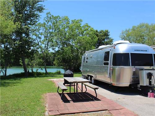 An Airstream trailer in a waterfront RV site at HIDDEN LAKE RV PARK