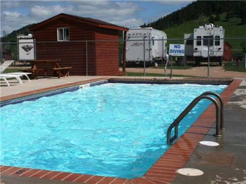 The pool with camp sites behind it at NO NAME CITY LUXURY CABINS & RV PARK