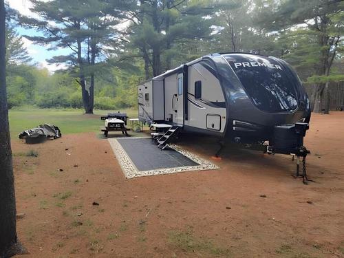 RV at site with picnic table in trees