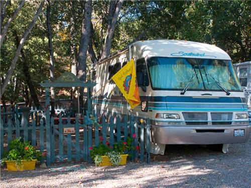 RV parked next to blue picket fence