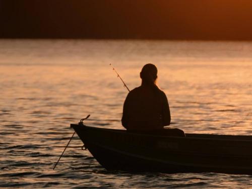 Person fishing in a boat at site Fairview Park Camping & Marina