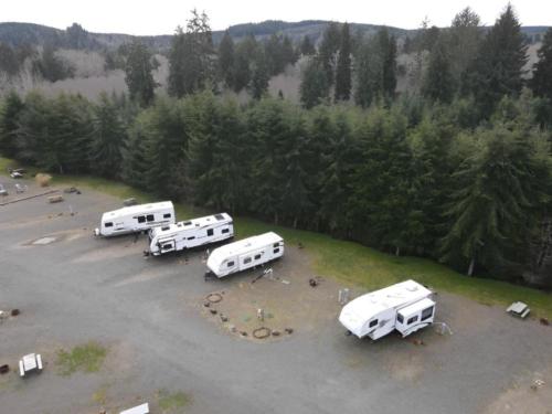 Parked travel trailer with woods in the background at Quileute Riverview RV Park