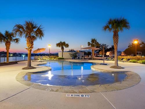 The pool and palm trees at Brazoria Lakes RV Resort