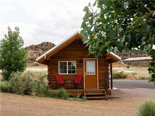 Exterior of cabin with chairs on front porch Escalante Grand Resort