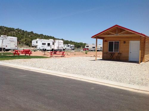 Rental cabin with red picnic tables at CROSS HOLLOW RV RESORT