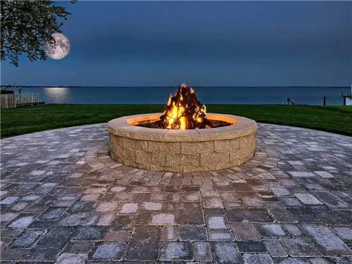 Fire pit with the moon over the lake at NORTHPOINTE SHORES RV RESORT