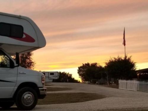 RV with view of flag at sunset at Al's Hideaway Cabins & RV Park