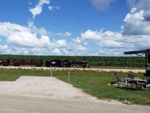 Miniature locomotive chugging down railroad tracks at Whistle Stop Campground