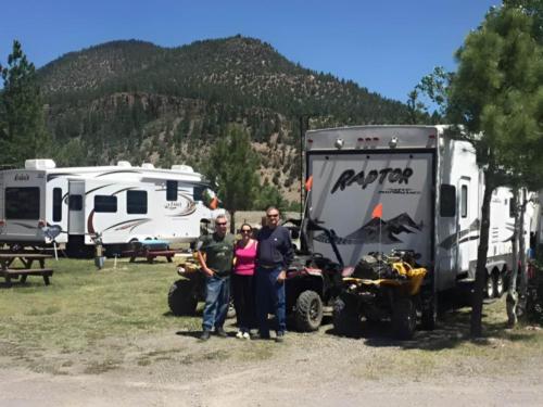 People standing in front of their ATVs and RV