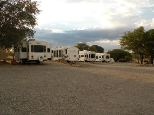 Gravel road with 5th wheels parked on gravel sites at Ridge Park RV & Campground
