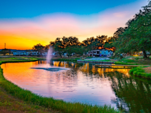 Lake with a fountain at Open Air Resorts Spicewood