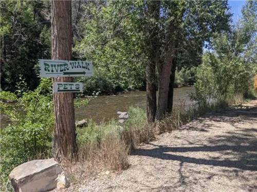 The walking trail next to the river at OUTPOST MOTEL CABINS AND RV PARK