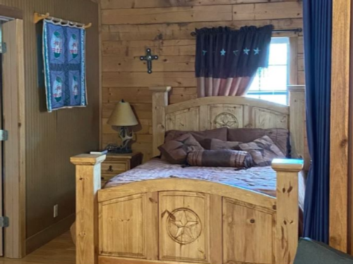 Cabin interior with wood bed frame at 	A Peace of Heaven Cabins and RV Park
