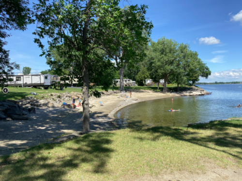Beach area with RV sites nearby at Sunset Rock RV Park & Lake Shore