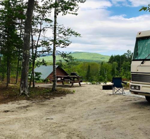 Panic area with RV and cabin at site Lone Mountain River Front Campground