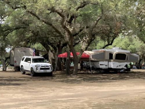 RV's parked under trees at Nueces River RV and Cabin Resort