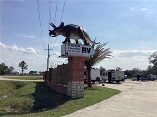 The front entrance sign with a statue on the top at GATOR RV PARK