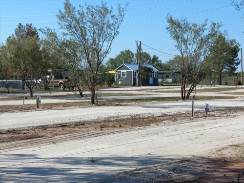 Dirt sites with a building at Weeping Willow RV Park