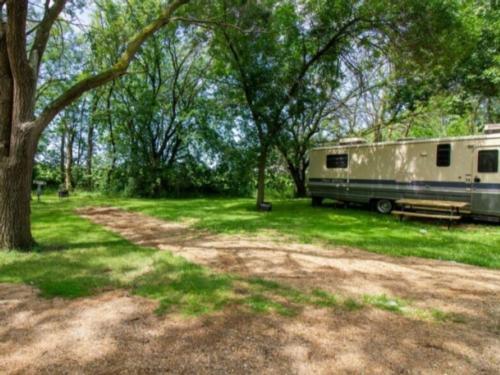 Gravel site by trees at Windmill RV Park Campground