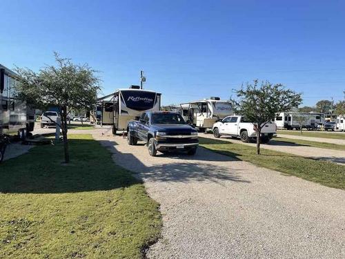 Open grass area next parked trailers Plantation Place RV Park