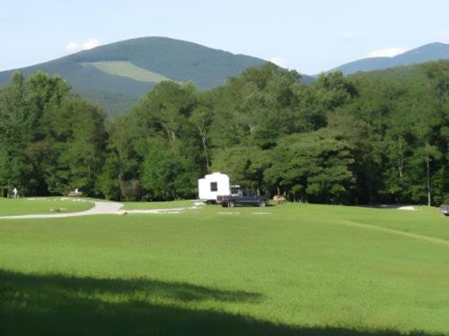 Parked trailer with large grass area at Blue Bear Mountain Camp