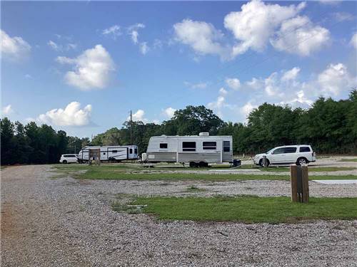 A few of trailers parked in gravel sites at KELLY CREEK RV PARK