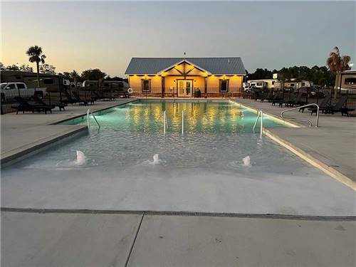 The outdoor pool lit up at dusk at SUN CITY RV PARK