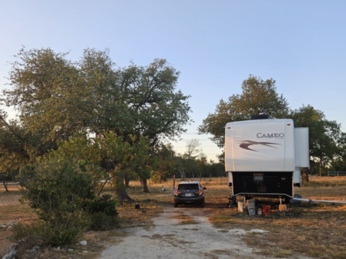 Vehicle and RV in grass site at Homestead Hill