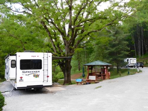 An RV with slide-outs in a shady site