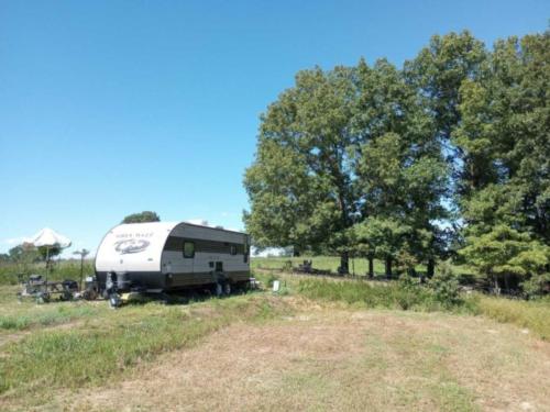 Camping trailer in a grassy site at Cedar Ridge RV Park & Storage