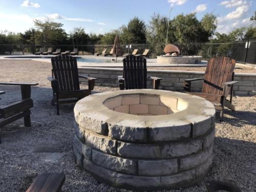 Adirondack chairs around a fire pit at BATL Ranch RV Resort