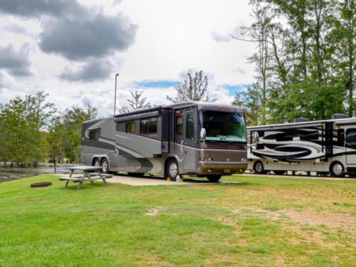 RVs by river and table at Paradise Ranch RV Resort