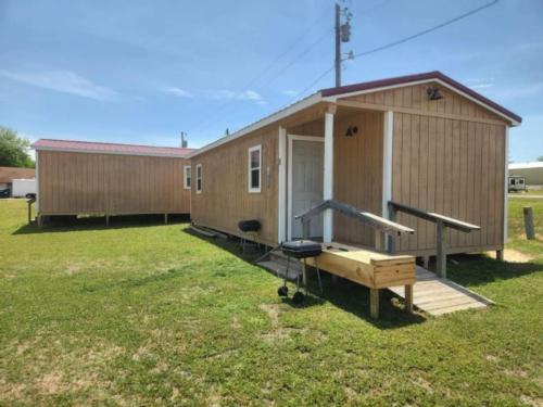 Two rentals surrounded by grass at The Bunkhouse Cabins and RV Park