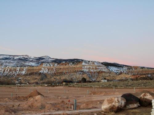 Dirt sites in front of snow topped hills at Capitol Reef RV Park & Glamping